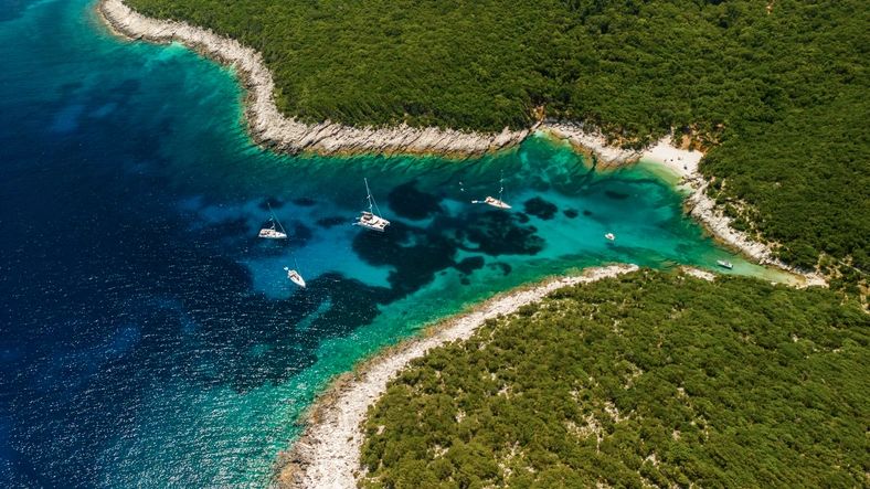 Sailboats anchored in a calm Greek bay